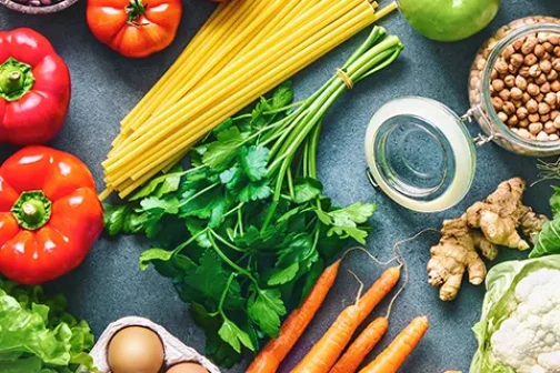 Flat lay of fruits, vegetables, greens, bread and oil
